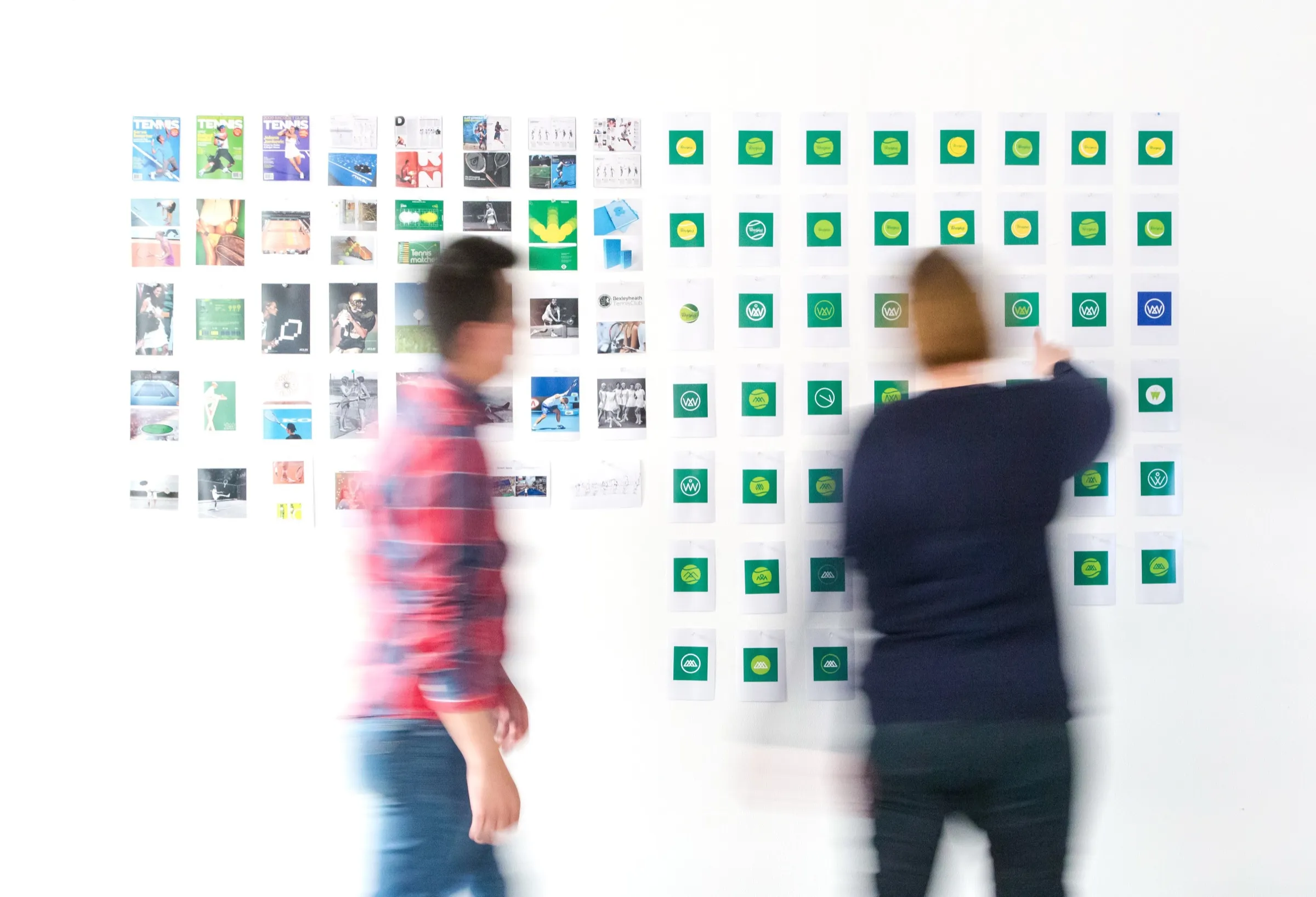 Designers reviewing brand boards on a wall